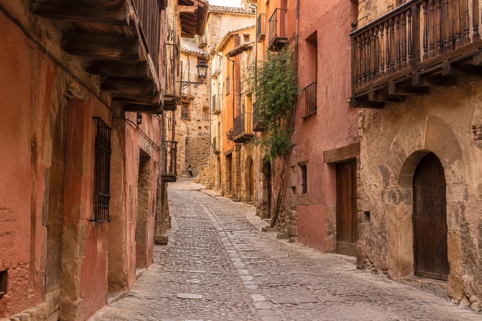 Calle medieval de Albarracín con casas rojizas, adoquines y balcones de madera