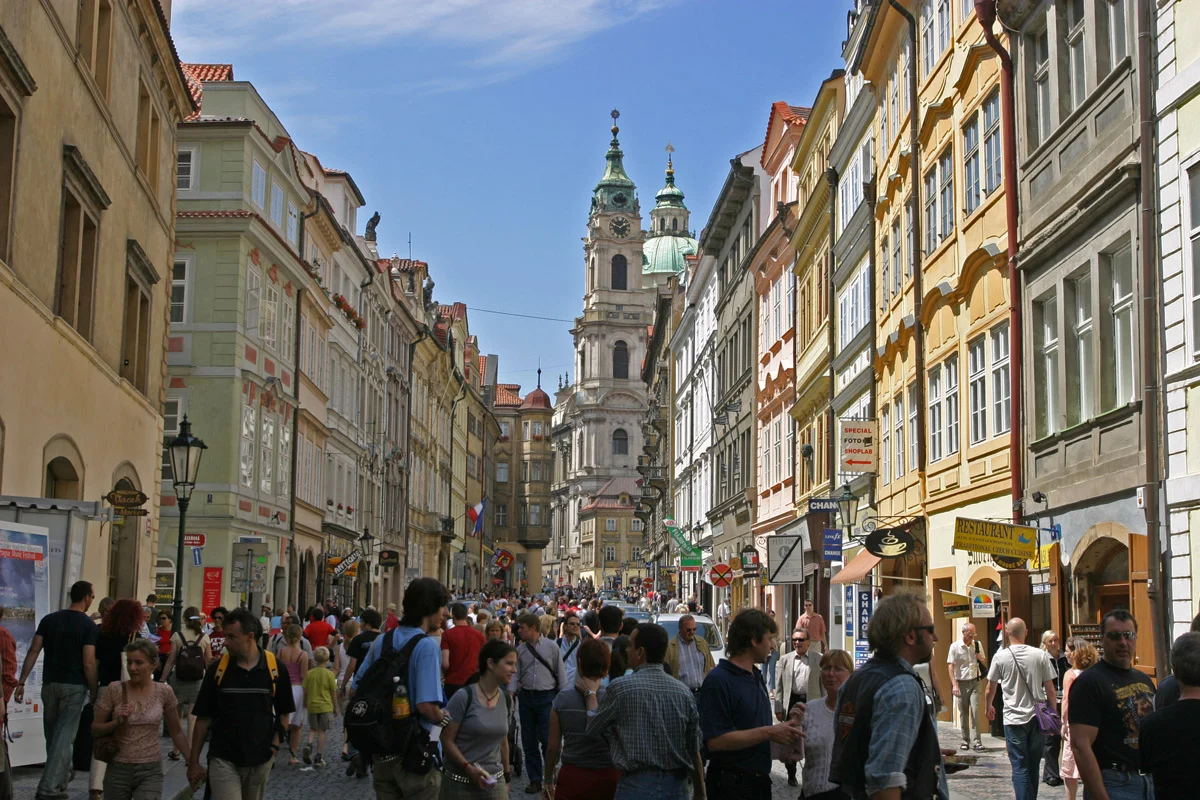 Calle de Malá Strana en Praga con edificios históricos y ambiente de visitantes