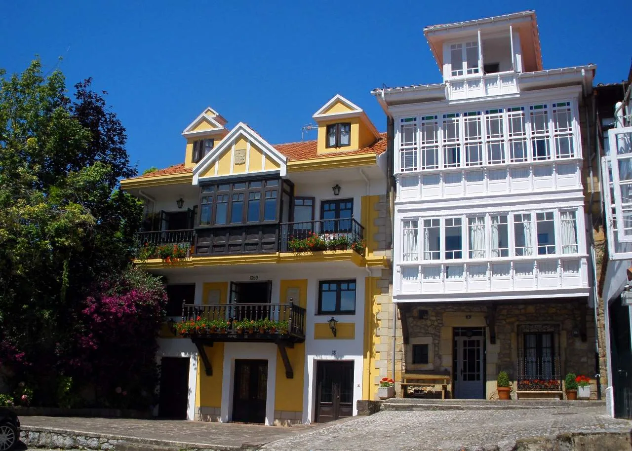 Casas con galerías acristaladas junto al empedrado del Corro de San Pedro en Comillas