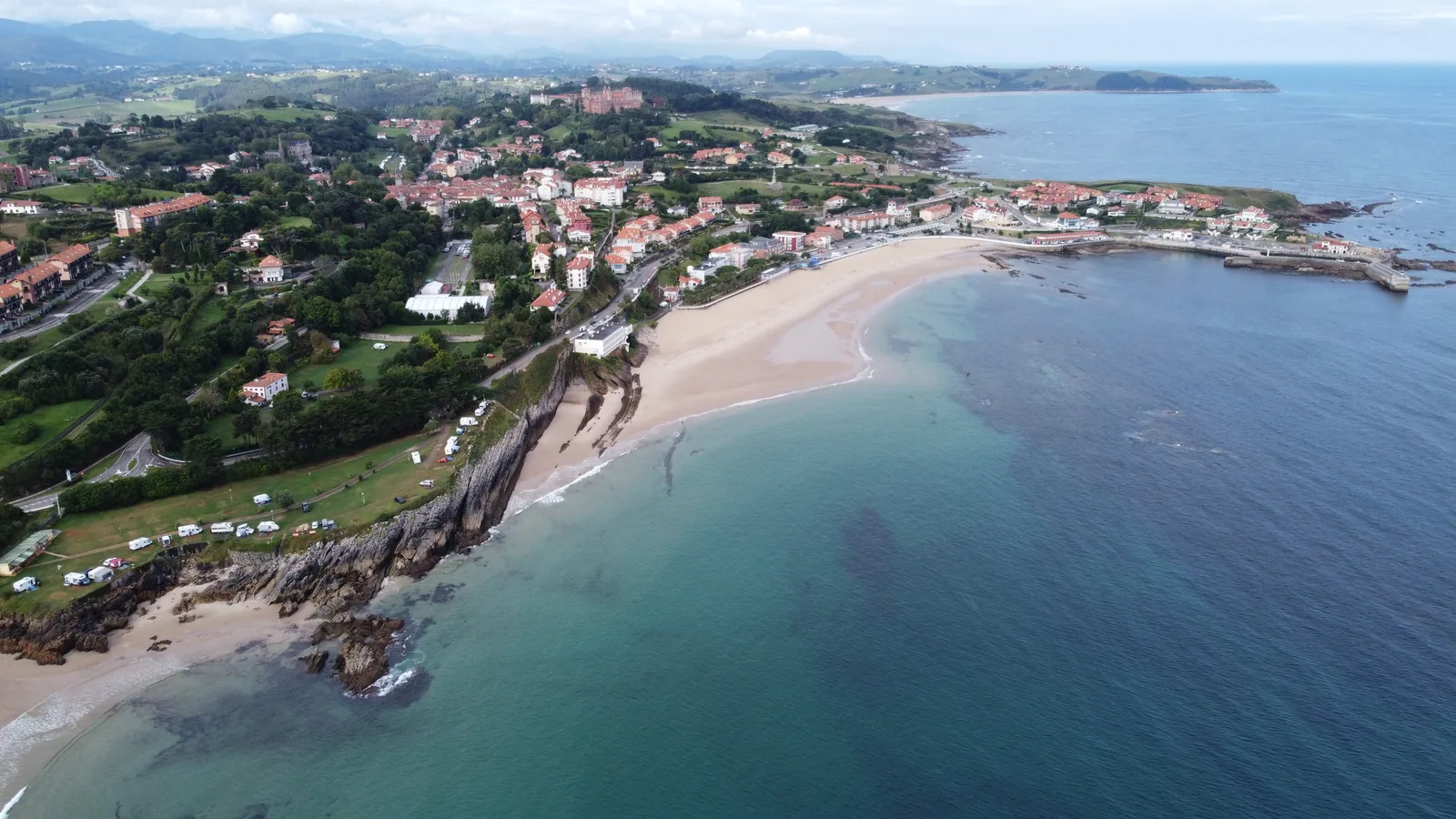 Vista aérea de la playa de Comillas, el puerto y las casas junto a la costa